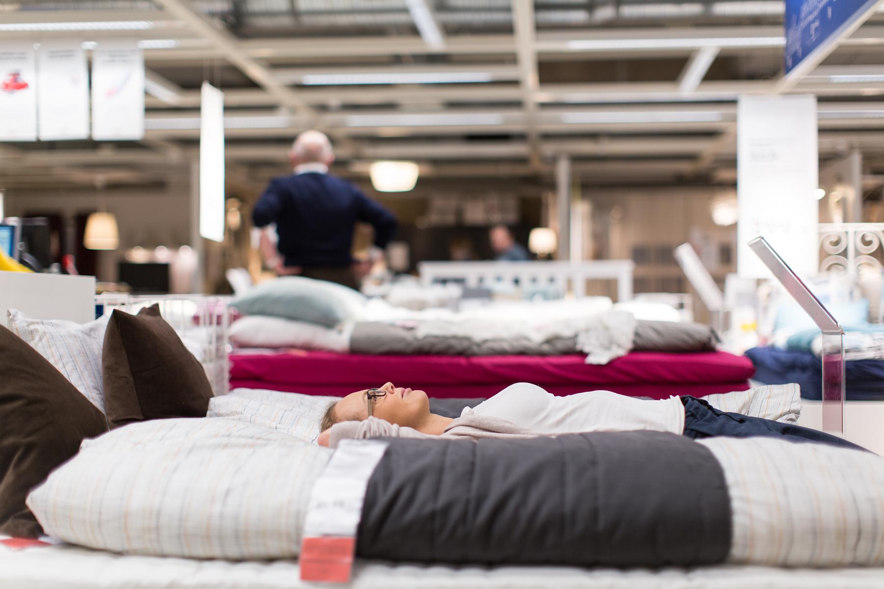 woman lying on mattress at mattress store