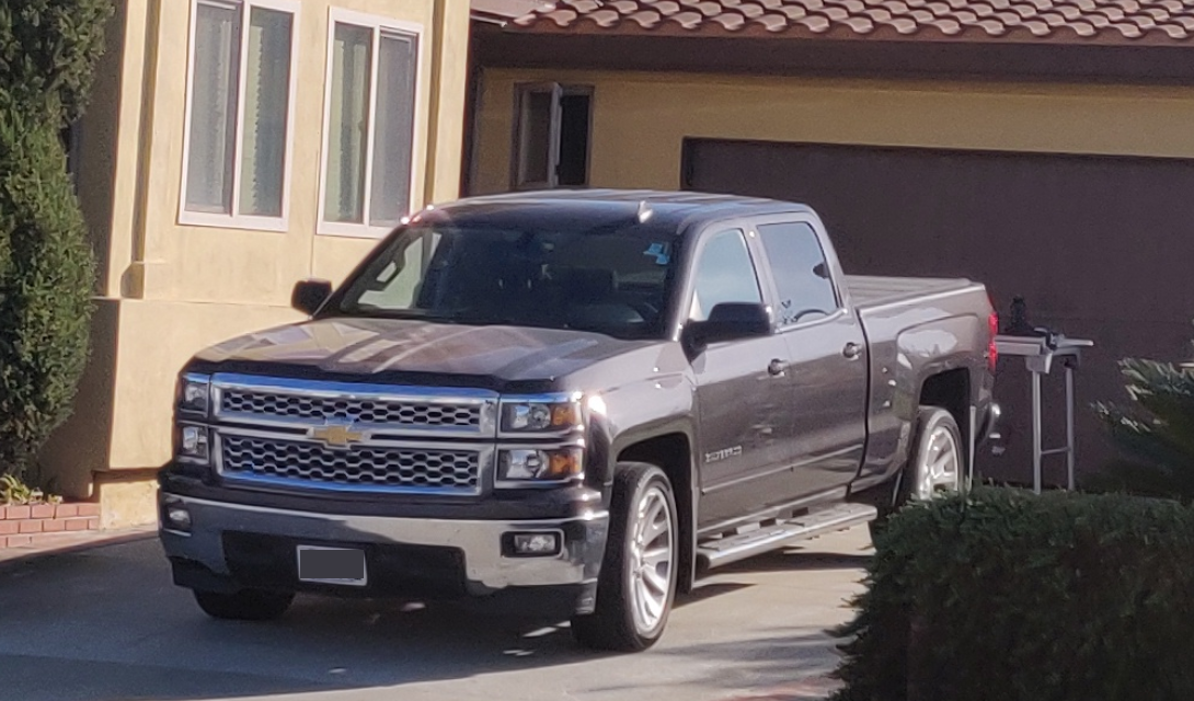 grey chevrolet silverado in front of garage