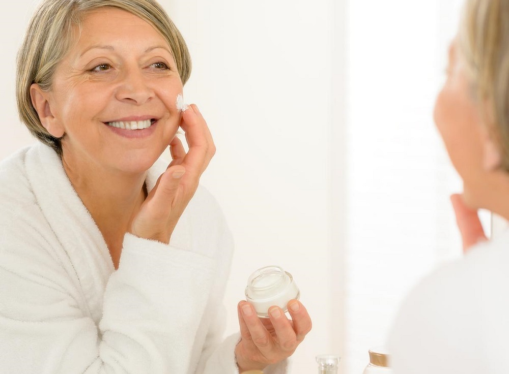 woman applying cream to face